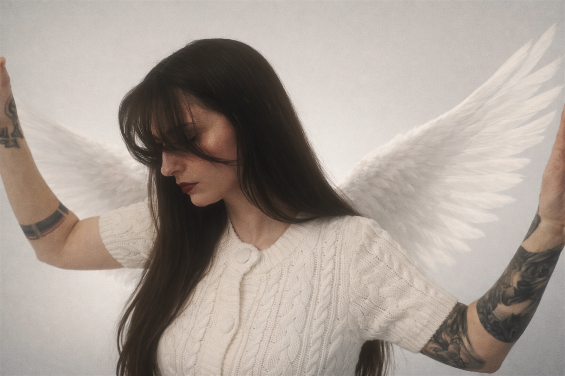 Portrait of Vae Bataille with white wings against a soft light background.