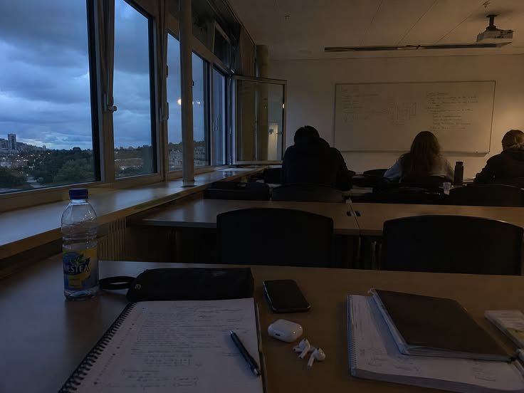 A seminar in progress beside an open window at dusk.