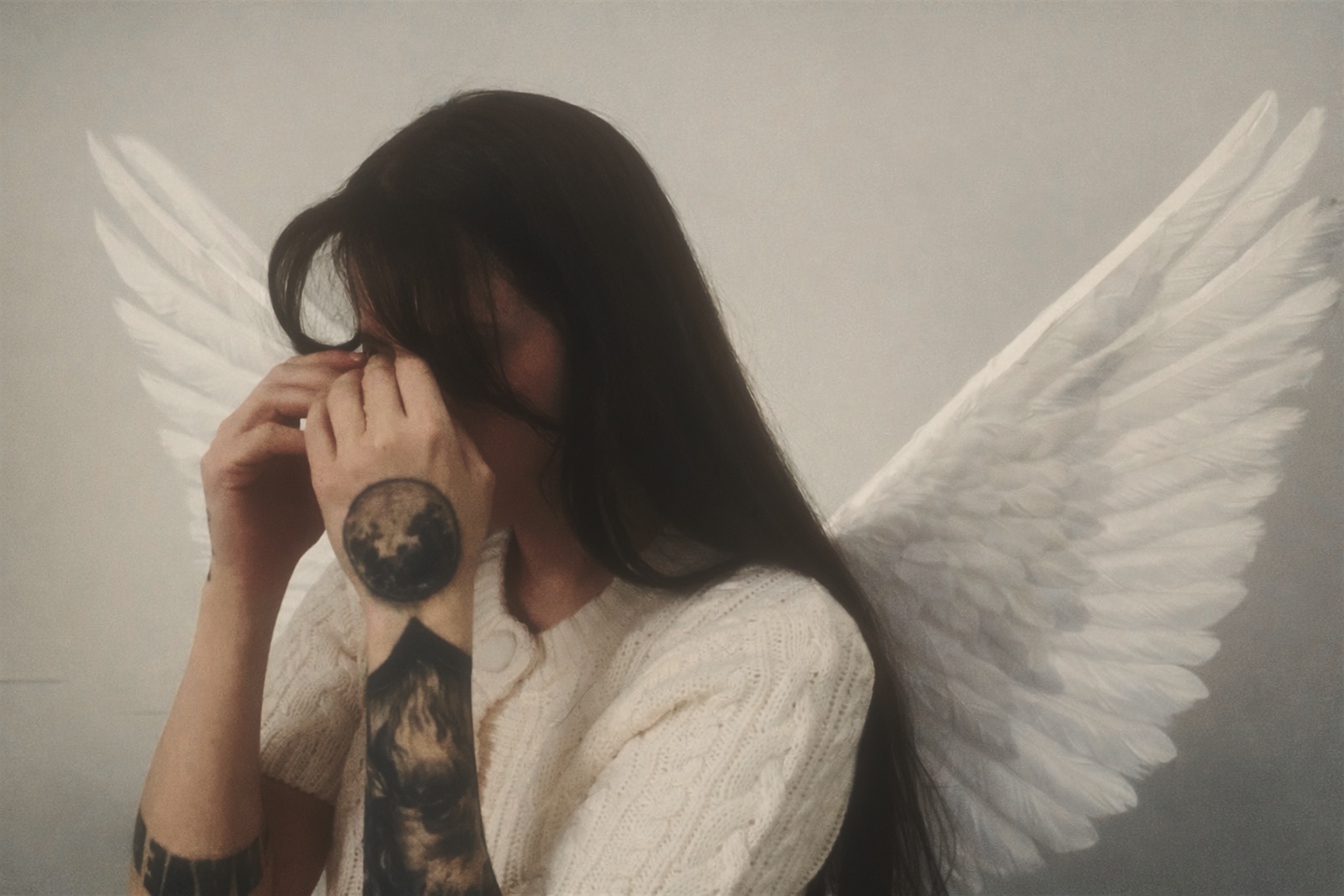 Portrait of Vae Bataille with white wings in soft light.
